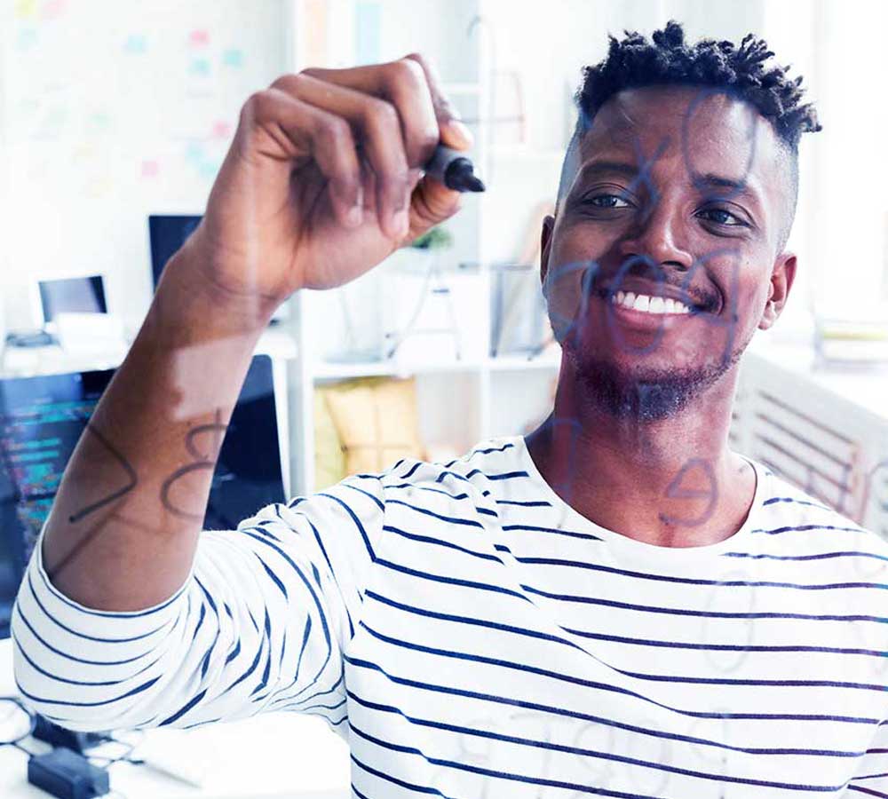 Smiling-african-man-writing-on-a-glass-board-with-marker-1